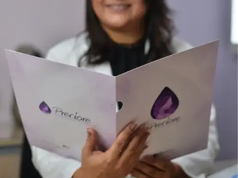 Pasta de exames da Clínica Preciore nas mãos de uma profissional