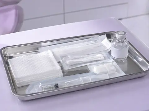 Bandeja estéril montada com gaze, seringa e frasco de anestésico