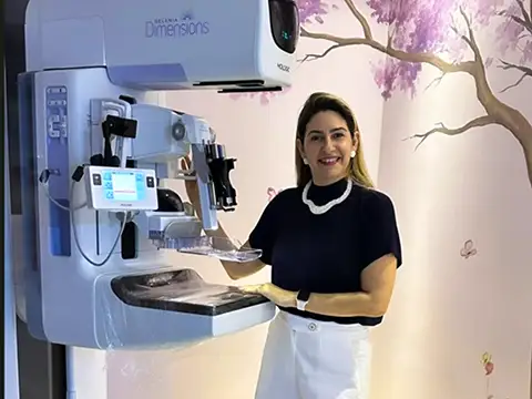 Profissional da Preciore ao lado do mamógrafo digital