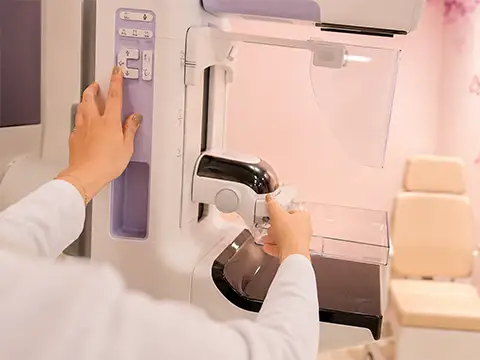 Técnica ajusta os controles do mamógrafo durante o exame